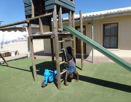Spelen op een speeltoestel in Vrygrond, Zuid-Afrika